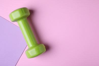 Bright dumbbell and space for text on color background, flat lay. Home fitness