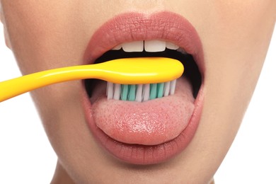 Photo of Woman brushing her tongue on white background, closeup. Dental care