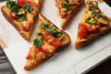 Photo of Tasty pizza toasts served on wooden table, closeup