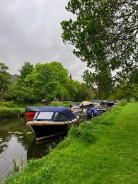 Beautiful view of green lawn near canal with different boats