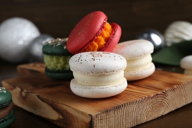 Beautifully decorated Christmas macarons and festive decor on wooden table, closeup