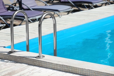 Photo of Modern swimming pool with step ladder outdoors