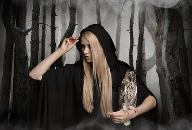 Image of Witch wearing black mantle with owl in foggy forest. Fantasy world