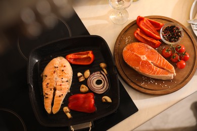 Photo of Composition with salmon steaks and vegetables in frying pan, above view
