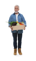 Harvesting season. Farmer holding wooden crate with vegetables on white background