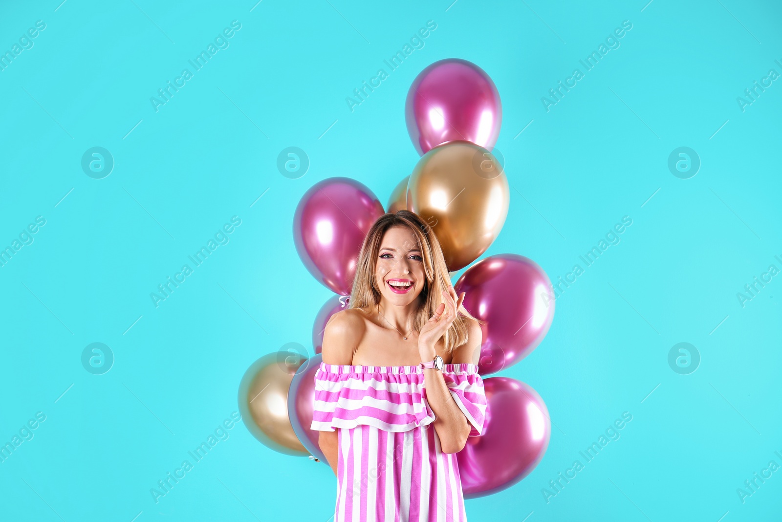 Photo of Young woman with air balloons on color background