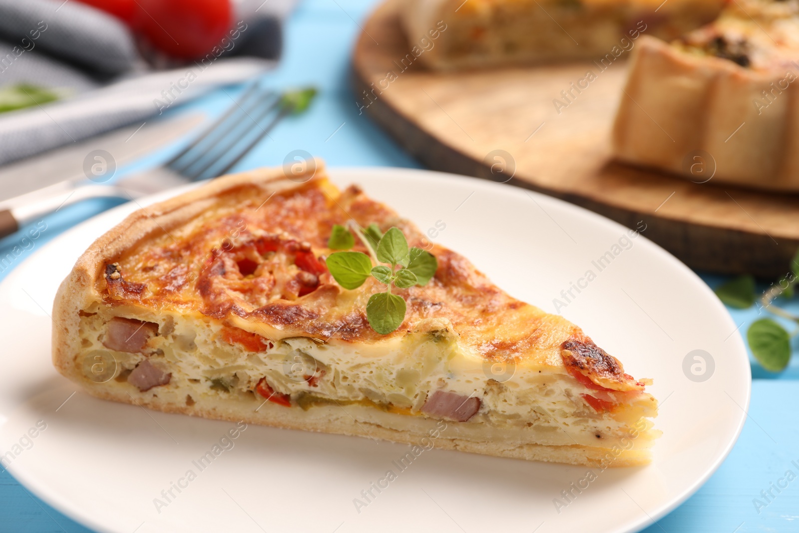 Photo of Piece of delicious homemade vegetable quiche on plate, closeup