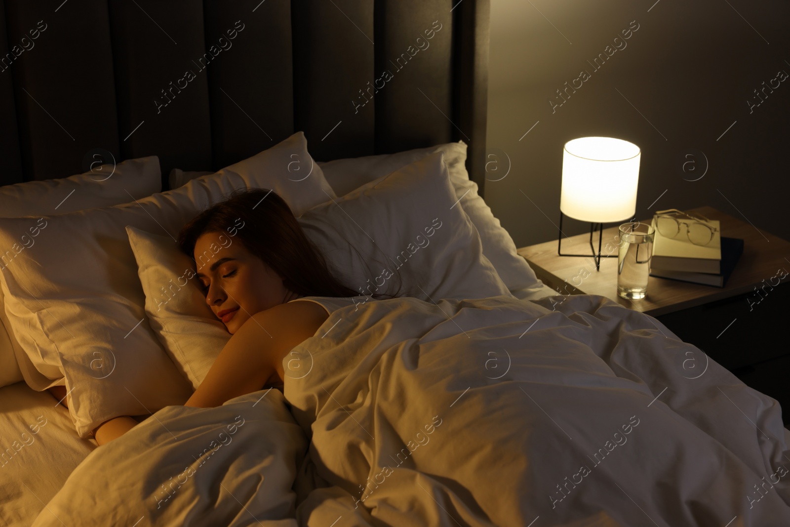 Photo of Beautiful young woman sleeping in bed at night