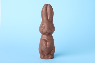 Photo of Chocolate bunny on light blue background. Easter celebration