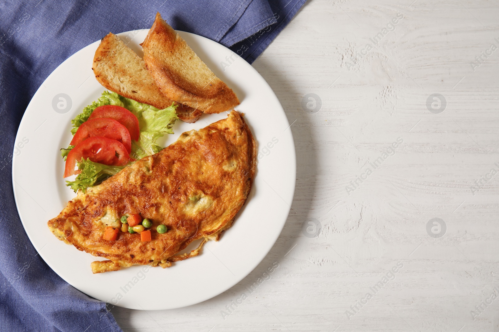 Photo of Omelet with vegetables on plate served for breakfast, top view