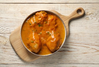 Tasty chicken curry on wooden table, top view