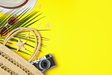 Flat lay composition with beach accessories on yellow background, space for text