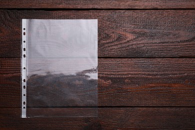 Empty punched pocket on wooden table, top view. Space for text