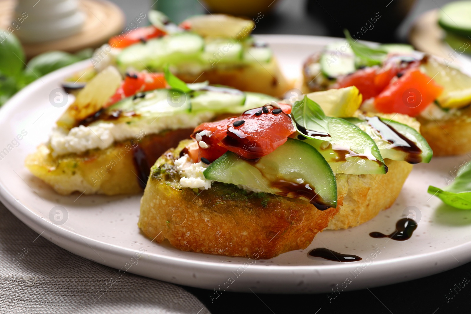 Photo of Delicious bruschettas with balsamic vinegar and toppings on table, closeup