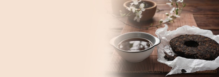 Image of Aromatic pu-erh tea on wooden table. Banner design with space for text