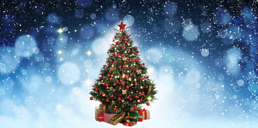 Image of Beautifully decorated Christmas tree on blue background, banner design. Bokeh effect