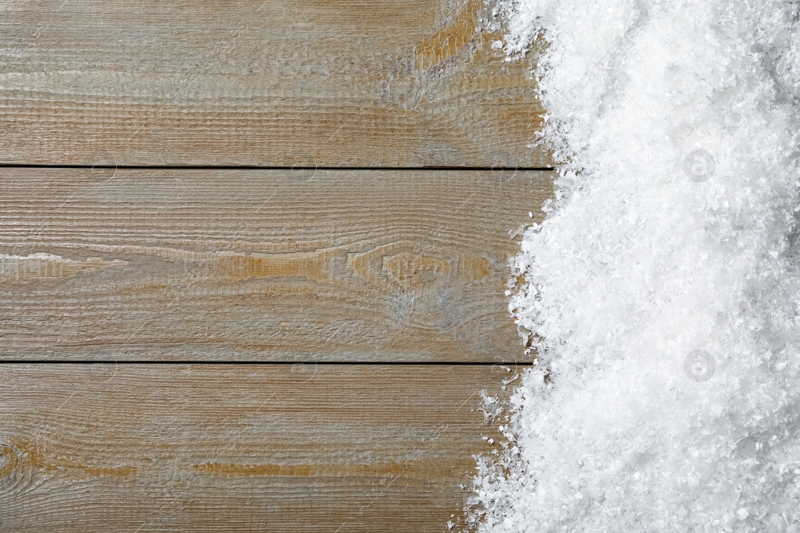 Photo of Snow and space for text on wooden background, top view. Christmas time