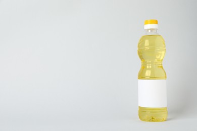 Bottle of cooking oil on light grey background. Space for text