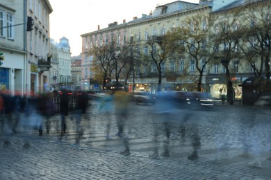 Photo of Blurred view of people crossing street in city