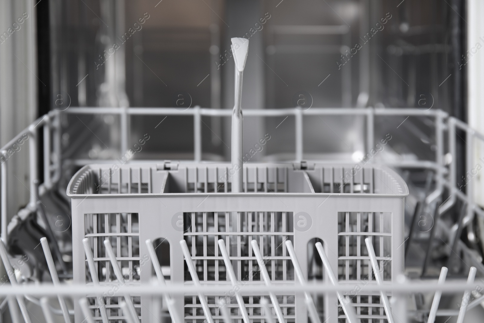 Photo of Open clean modern empty automatic dishwasher machine, closeup