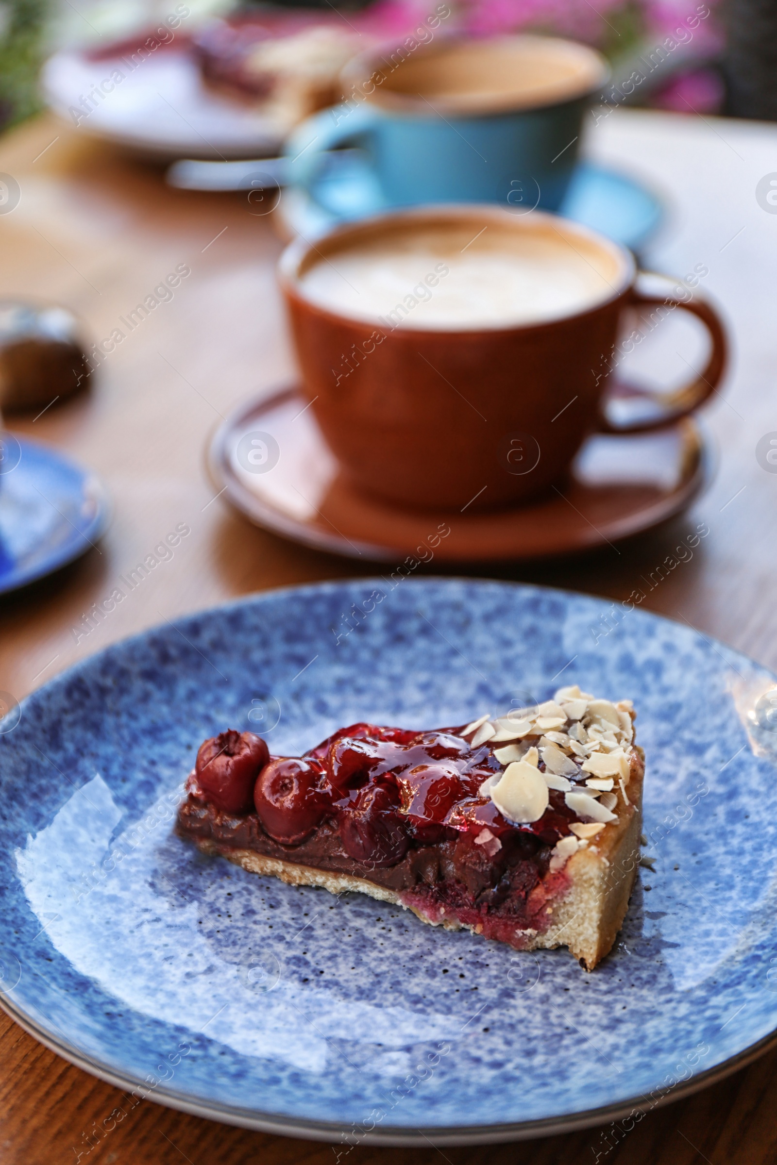 Photo of Plate with slice of cherry cake on wooden table