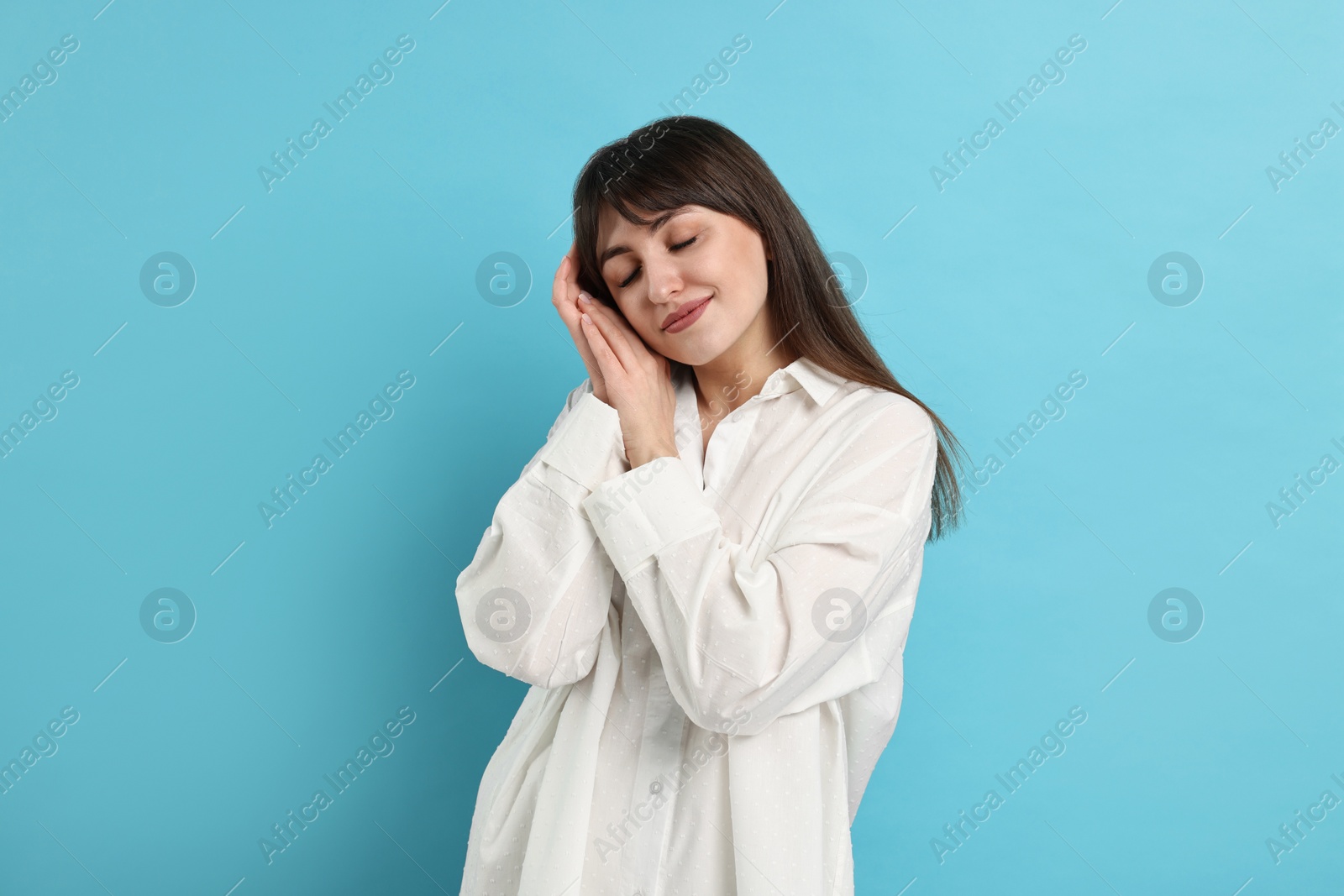 Photo of Woman in pyjama sleeping on light blue background