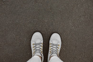 Photo of Woman standing on asphalt, top view. Space for text