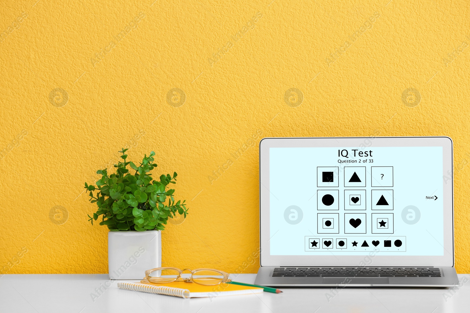 Image of Modern laptop with IQ test on screen near yellow wall