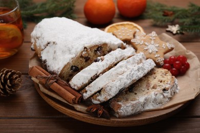 Traditional Christmas Stollen with icing sugar on wooden table