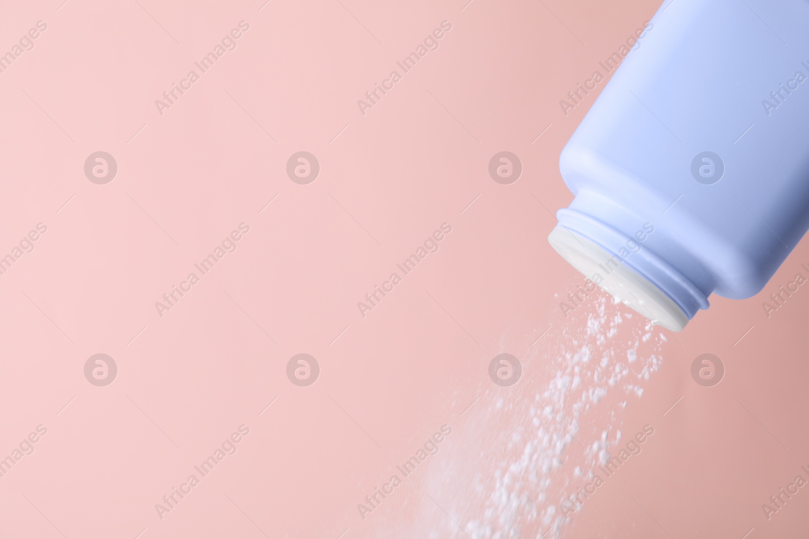 Photo of Scattering of baby powder on pink background, closeup. Space for text