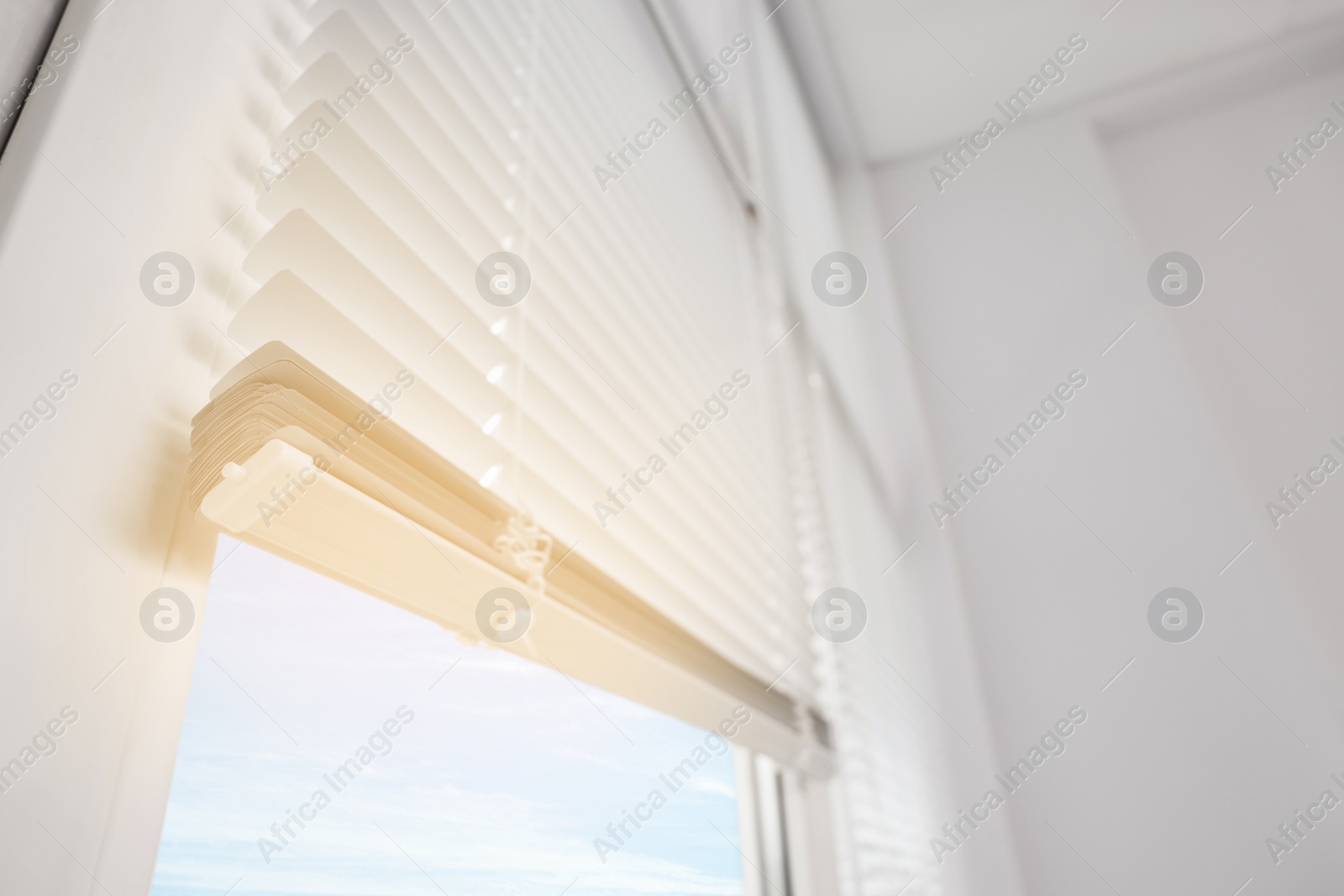 Photo of Stylish window with horizontal blinds in room, low angle view