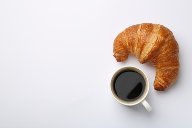 Photo of Delicious fresh croissant and cup of coffee on white background, flat lay. Space for text