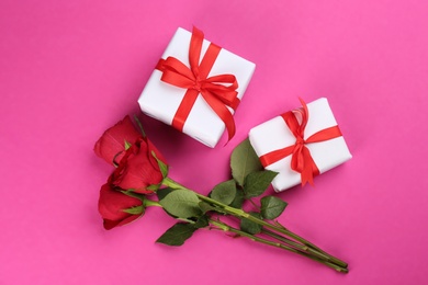 Photo of Beautiful gift boxes and roses on pink background, flat lay. Valentine's day celebration