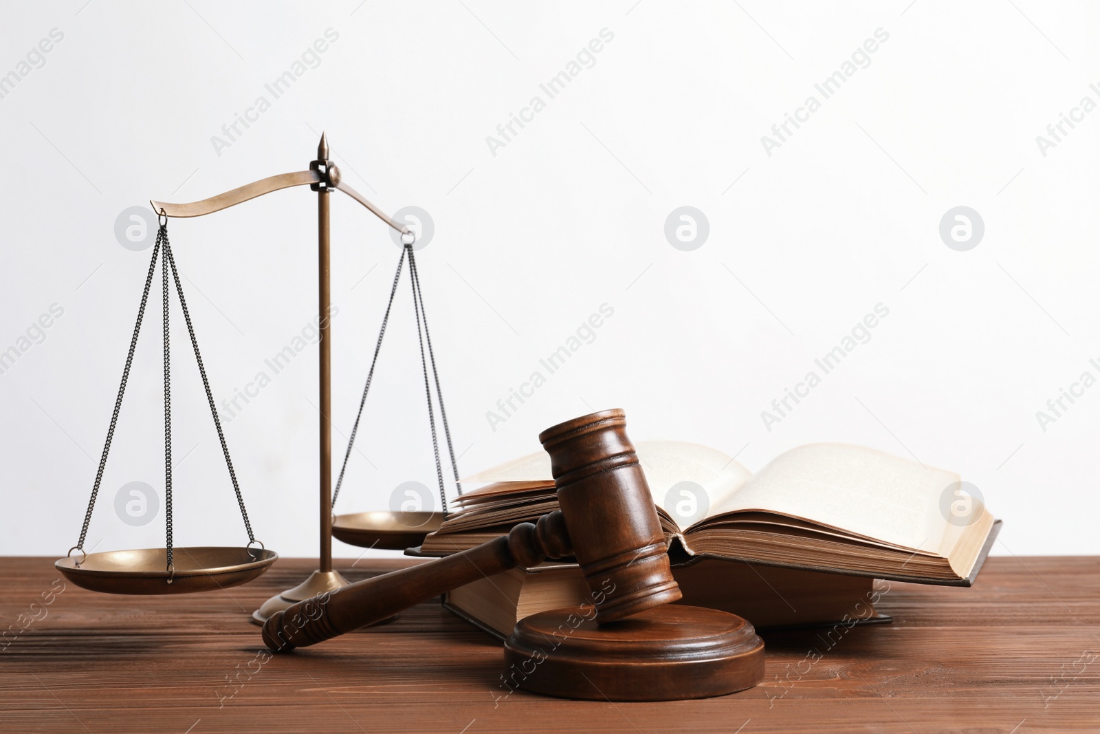 Photo of Wooden gavel, scales of justice and books on table. Law concept