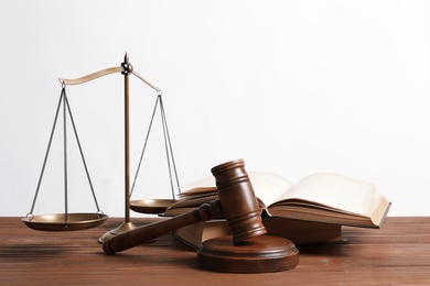 Photo of Wooden gavel, scales of justice and books on table. Law concept