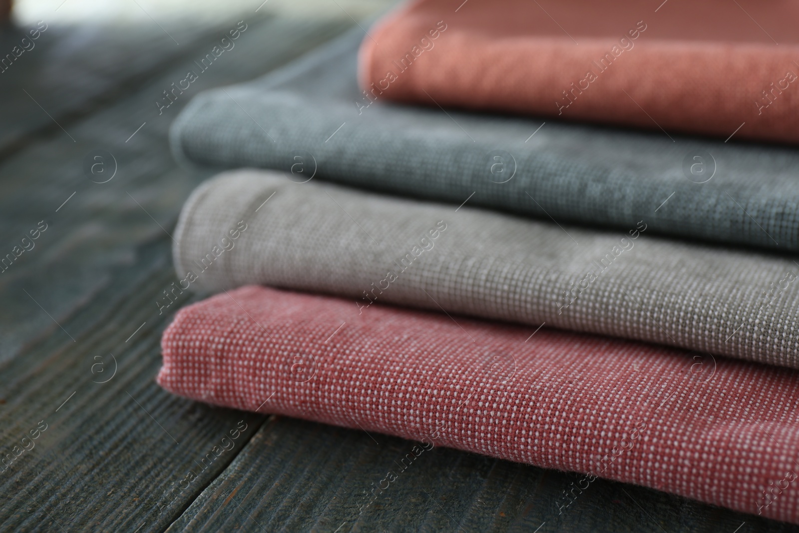 Photo of Different colorful napkins on wooden table, closeup