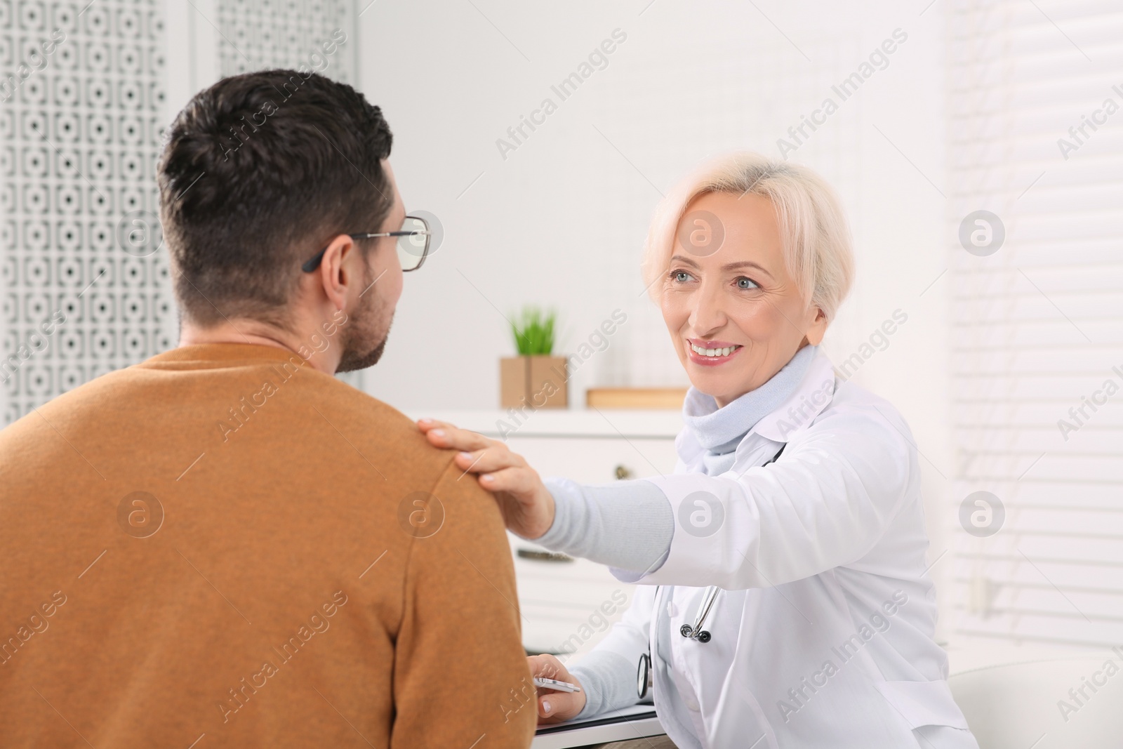 Photo of Professional female doctor consulting patient in clinic