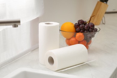 Photo of Rolls of paper towels on white countertop in kitchen