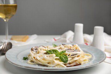 Photo of Delicious pasta with mushrooms and cheese on white table, closeup