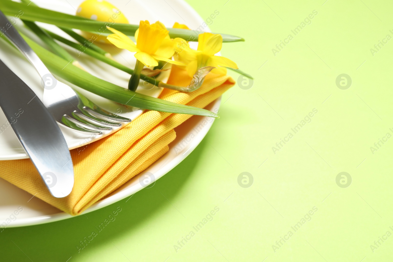 Photo of Festive Easter table setting with beautiful narcissuses, closeup. Space for text