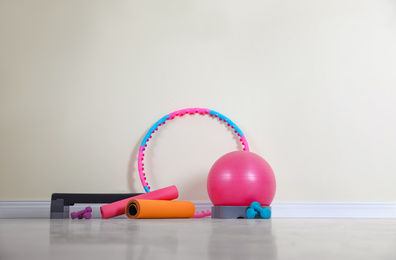Photo of Different sports equipment near light wall in gym
