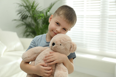 Little boy with toy bear at home