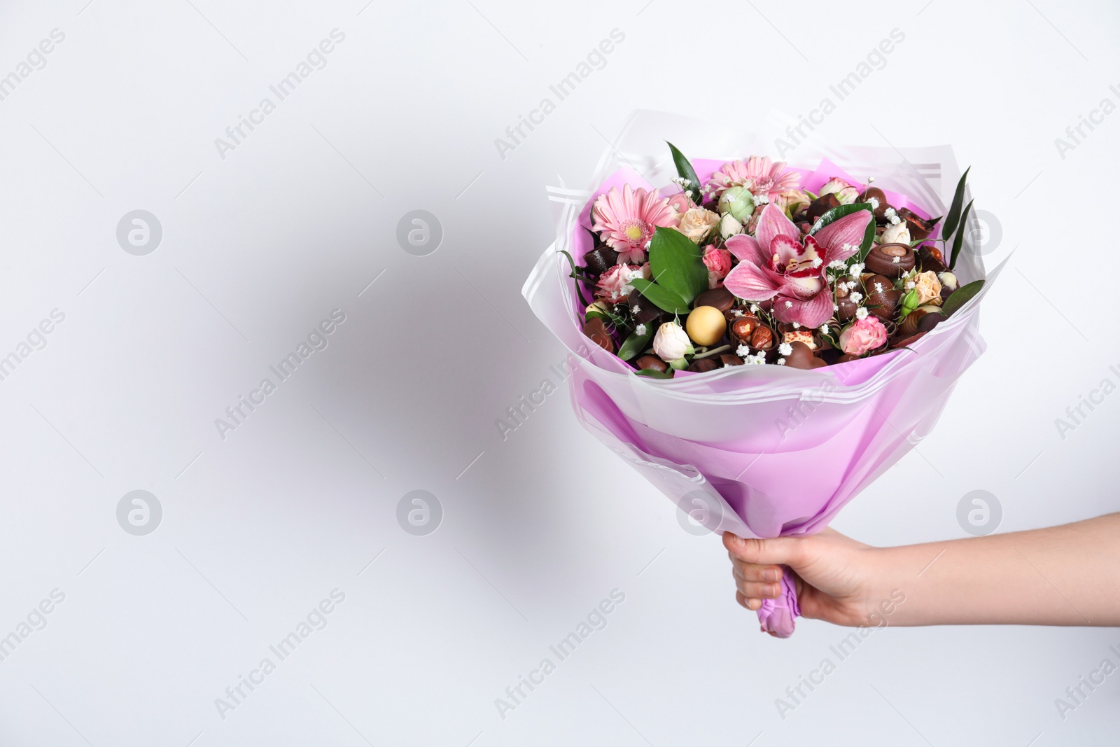 Photo of Woman with beautiful edible bouquet on white background, closeup. Space for text