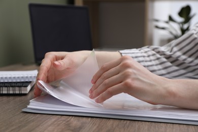 Photo of Woman with punched pockets at wooden table, closeup