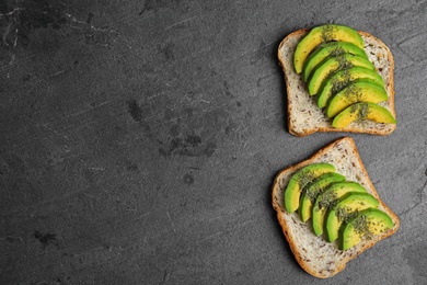 Tasty toasts with avocado on black table, flat lay. Space for text