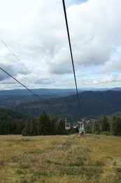 Photo of Ski lift and green trees at mountain resort