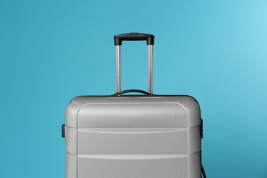 Photo of Stylish carry on suitcase on color background