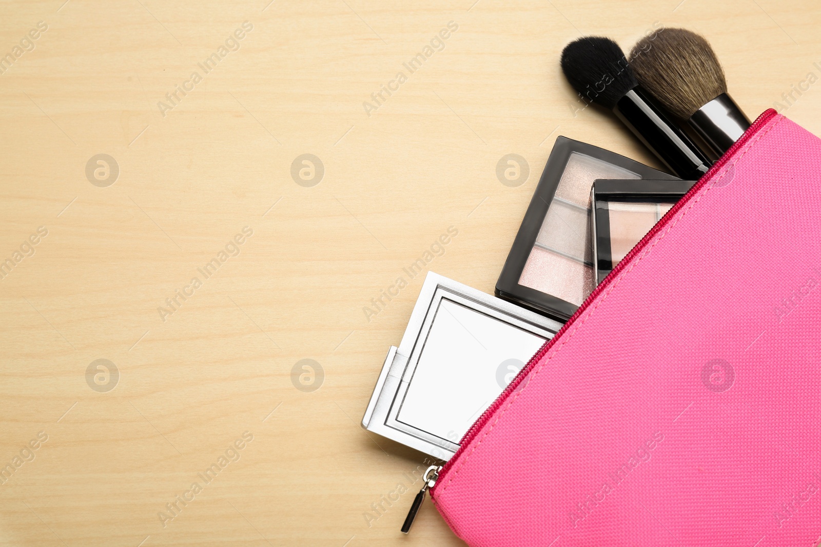 Photo of Cosmetic bag with pocket mirror and makeup products on wooden background, flat lay. Space for text