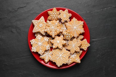 Tasty Christmas cookies on black table, top view