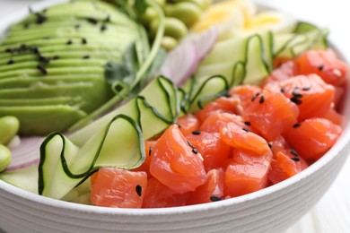 Photo of Delicious poke bowl with fish, cucumber and avocado, closeup